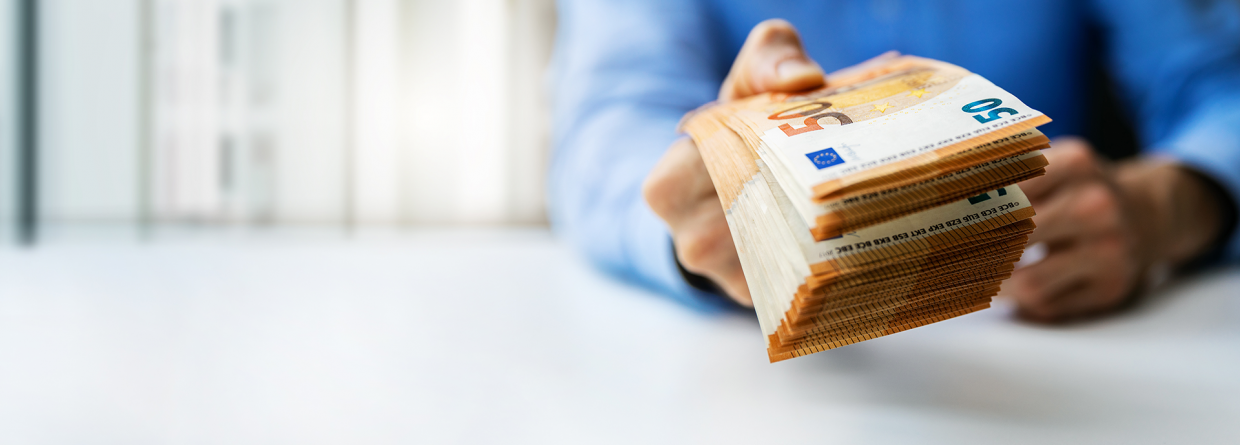 Man met een stapel briefjes van 50 euro in zijn hand